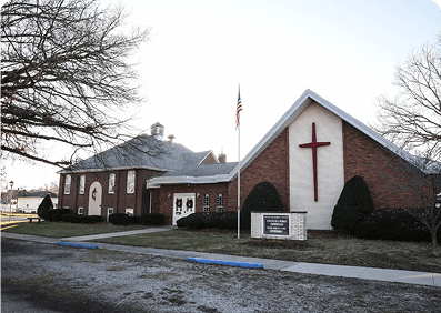 Brick church with red cross and sign