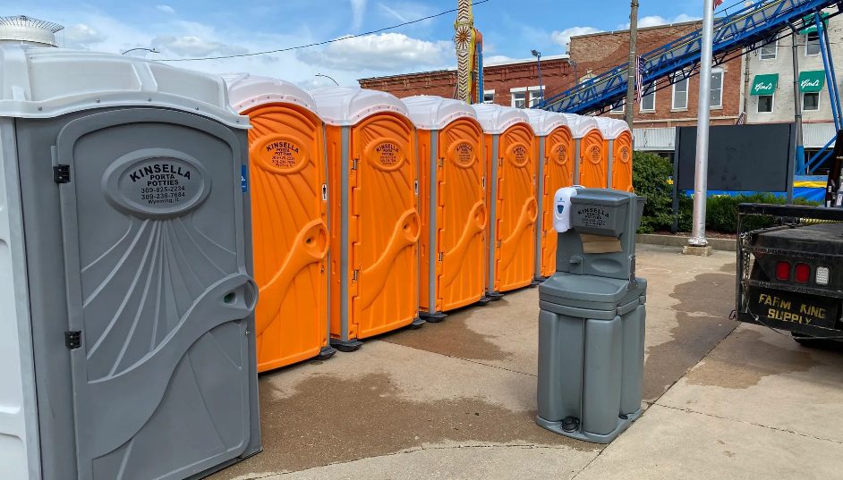 Row of orange portable toilets and handwashing station