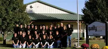 Large group posing outside a company building