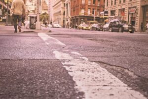 Low-angle city crosswalk with pedestrian walking