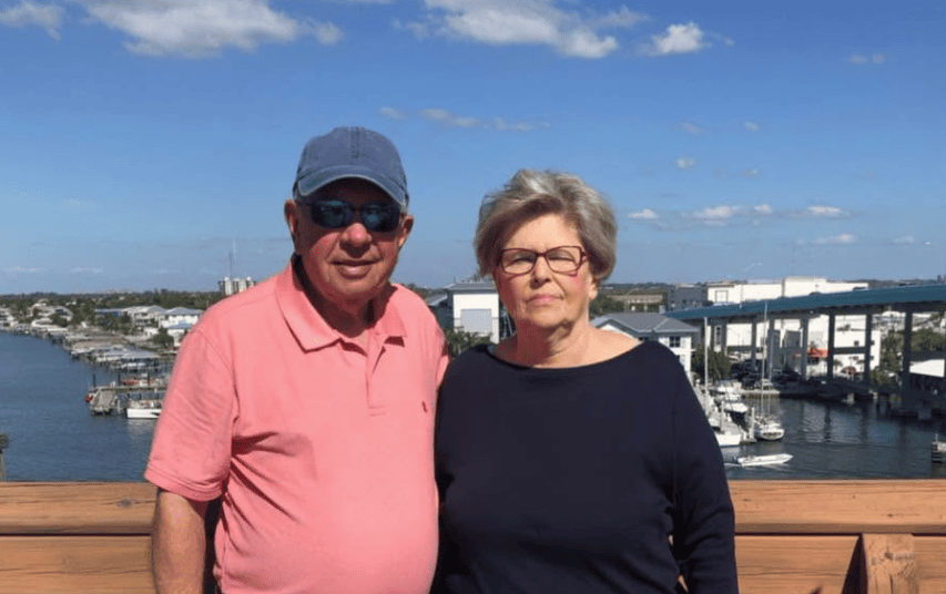 Older couple standing on marina boardwalk